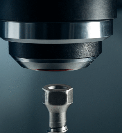 Nahaufnahme eines medizinischen Implantats, das unter einem Mikroskop begutachtet wird – Symbol für Präzision in der Medizintechnik.